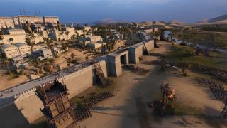 Total War: Pharaoh screenshot showcases a major siege with various ladders against walls while enemies fight defenders in ancient Egypt