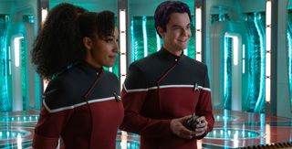 two characters in starfleet uniforms in front of transporters