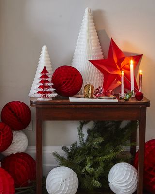An assortment of red and white Christmas paper honey decorations on hallway table
