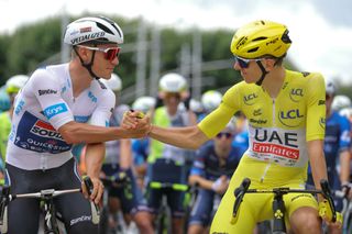 Soudal Quick-Step team's Belgian rider Remco Evenepoel (L) shakes hands with UAE Team Emirates team's Slovenian rider Tadej Pogacar wearing the overall leader's yellow jersey (R) at the start of the 6th stage of the 111th edition of the Tour de France cycling race, 163,5 km between Macon and Dijon, on July 4, 2024. (Photo by Thomas SAMSON / AFP)