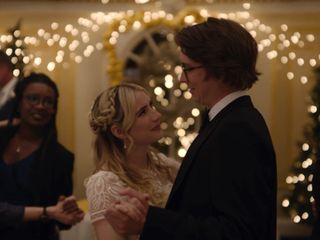a couple (emma roberts and thomas mann) dance in a wedding hall lit by fairy lights as guests watch them, in the rom-com 'about fate'
