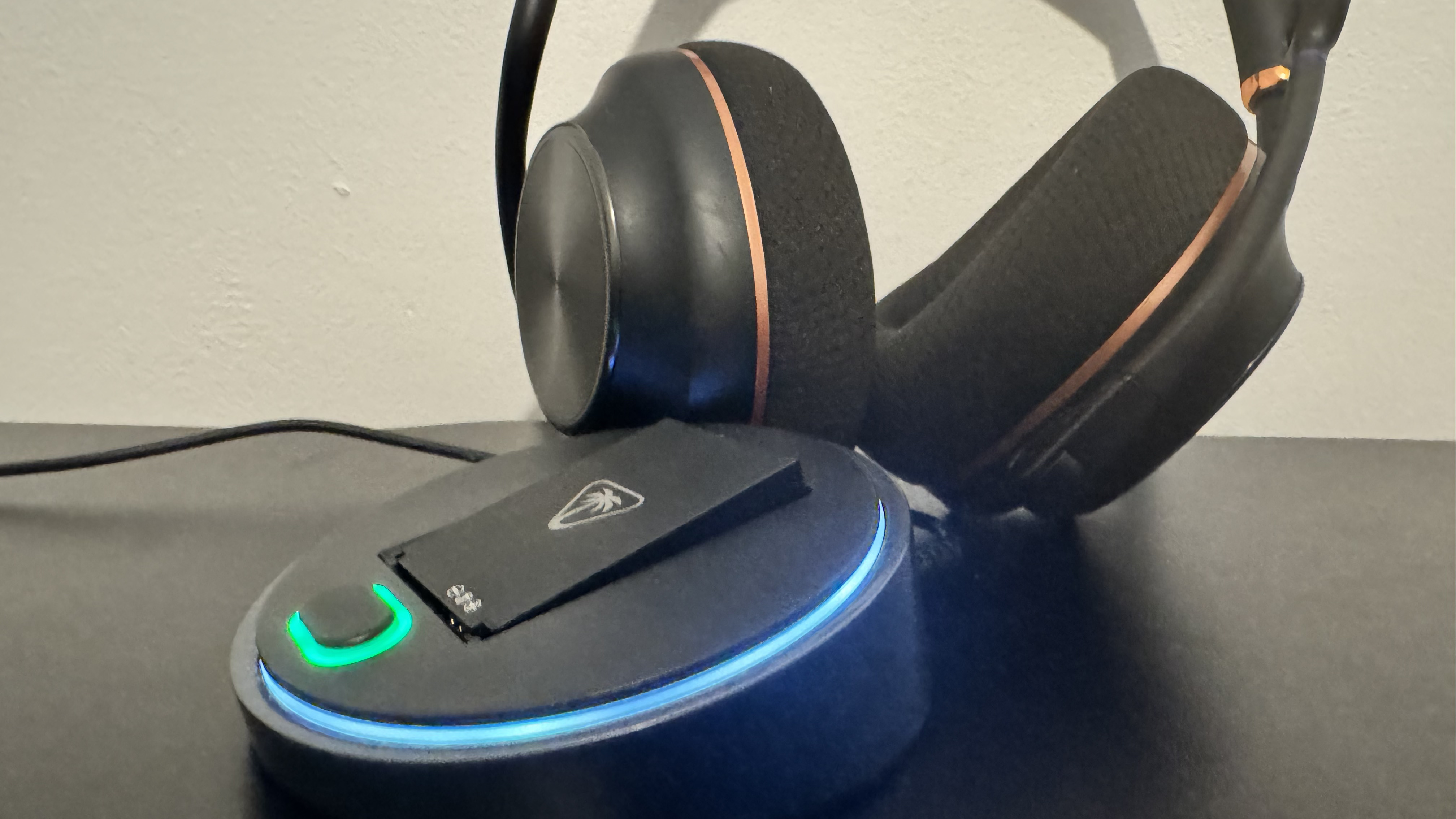 The Turtle Beach Stealth Pro II next to its receiver on a black desk