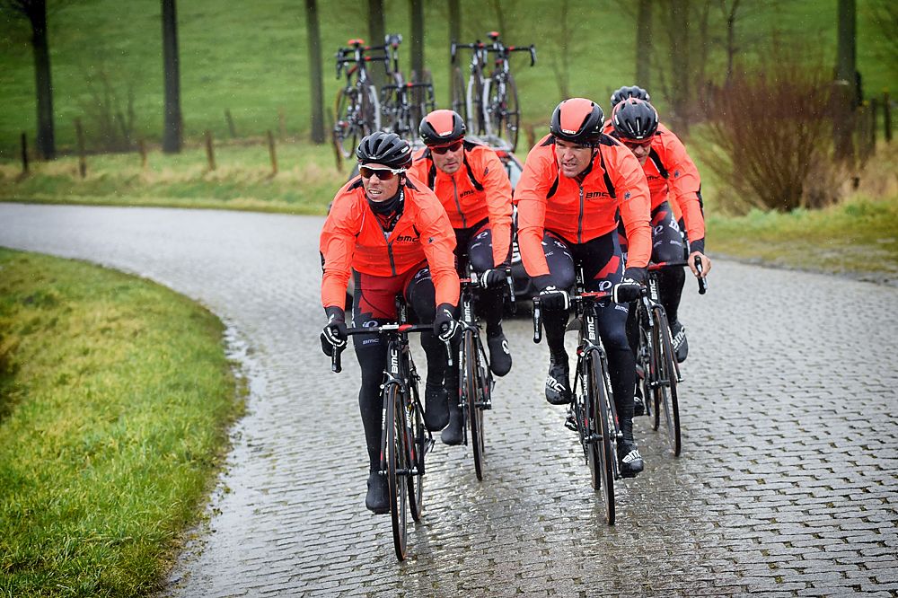 The BMC team kitted out in orange rain jackets for the pre-ride
