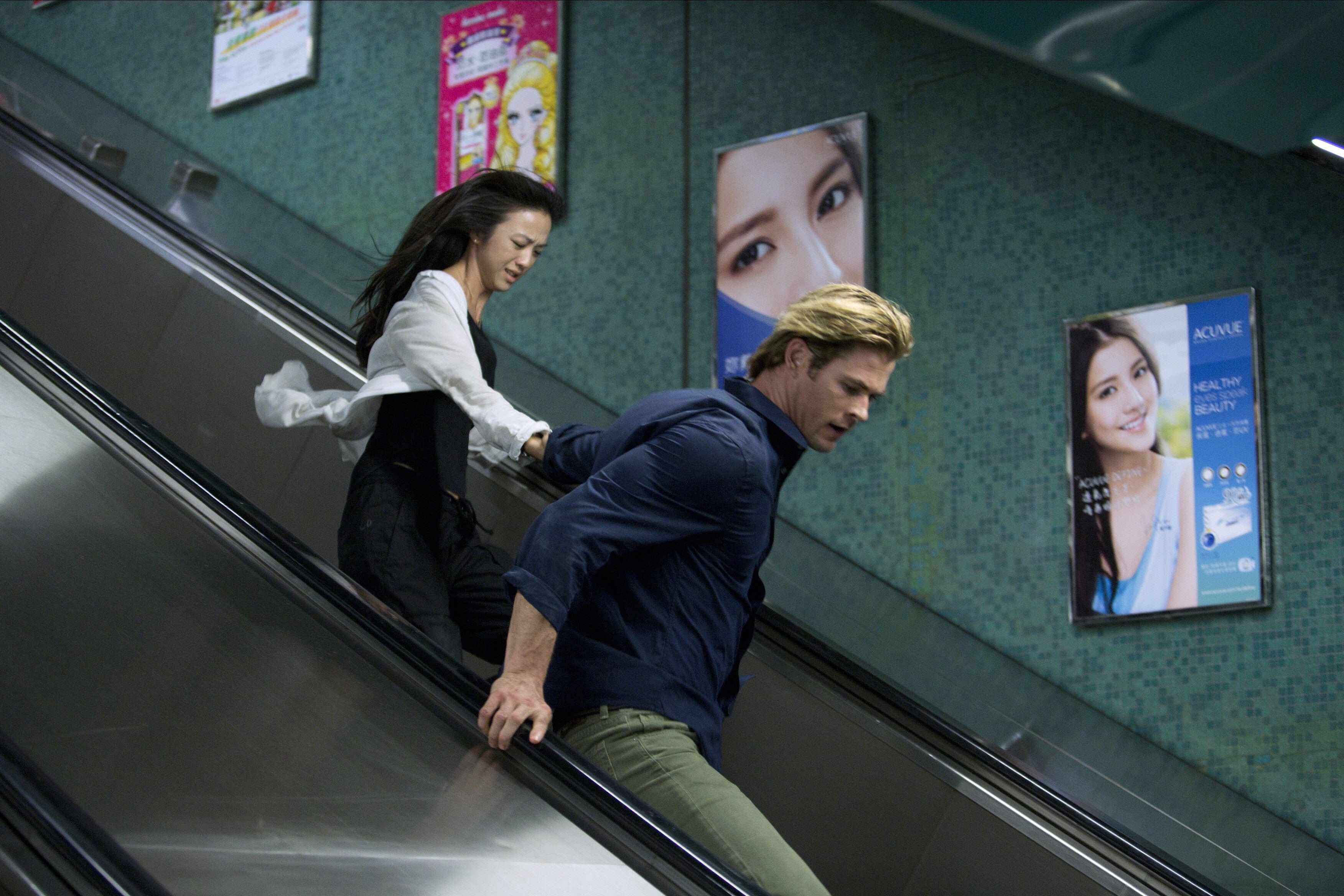 Nicholas Hathaway (Chris Hemsworth) und Chen Lien (Tang Wei) rennen in Blackhat eine Rolltreppe hinunter