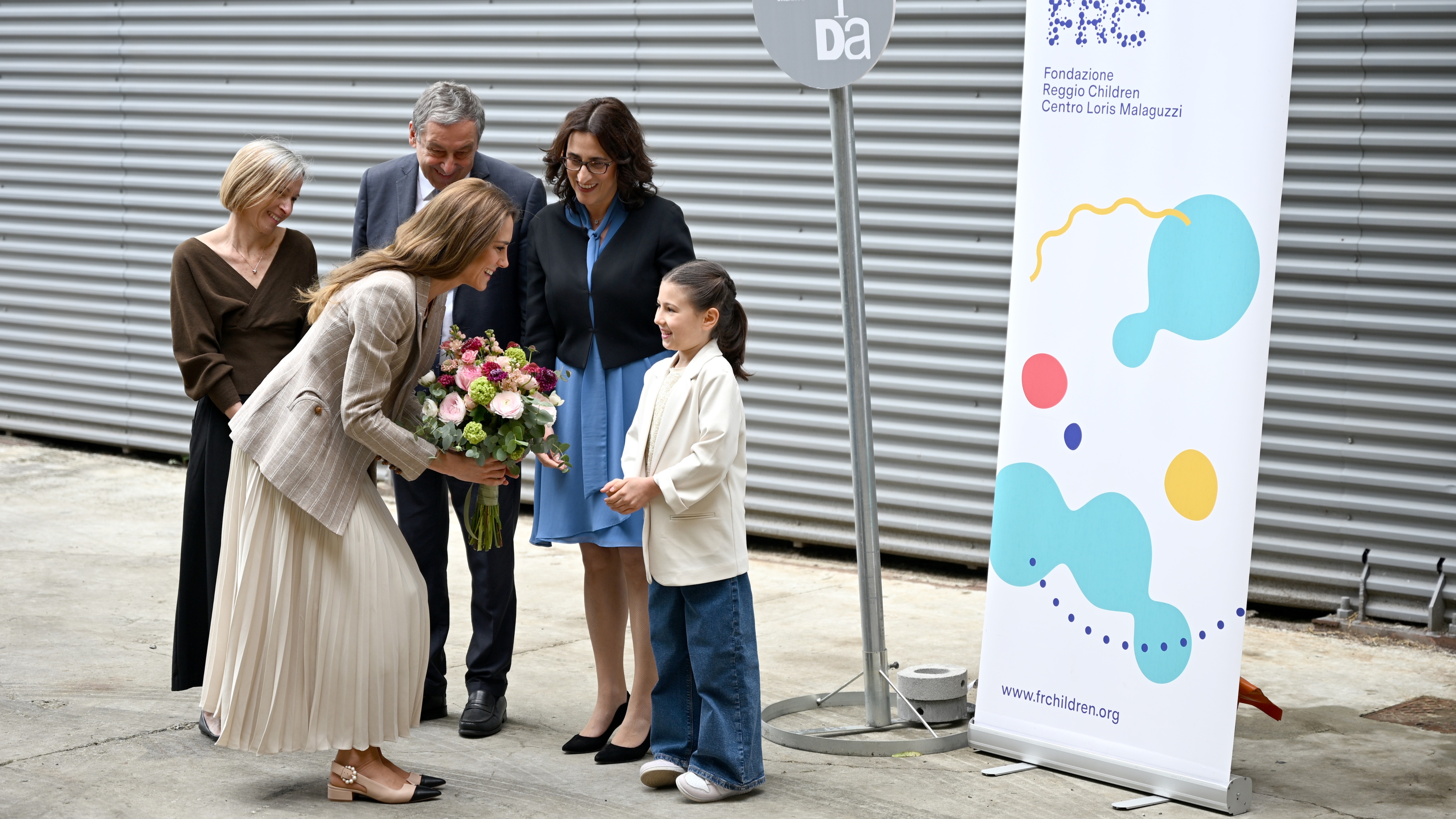 Catherine, Princess of Wales receives a bouquet of flowers from a young well-wisher with (L-R) Eloisa Di Rocco, Francesco Profumo and Barbara Donnici