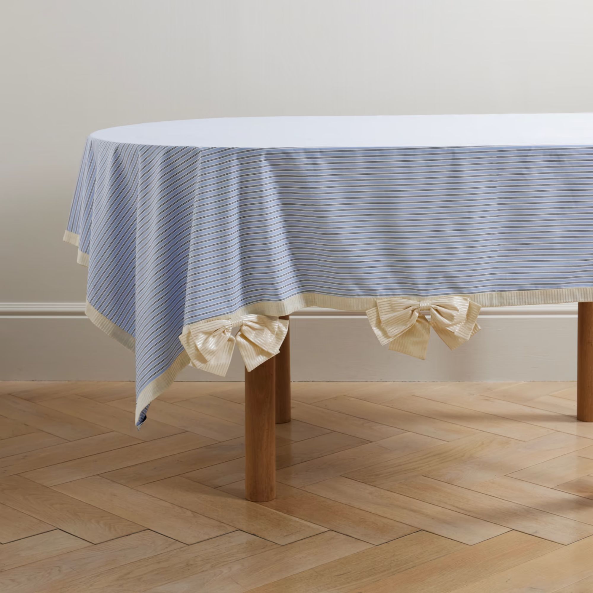 Blue and white striped tablecloth with white trim and white bows