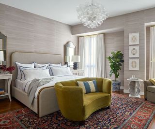 bedroom with textured wallcovering in taupe and mustard loveseat and vintage rug
