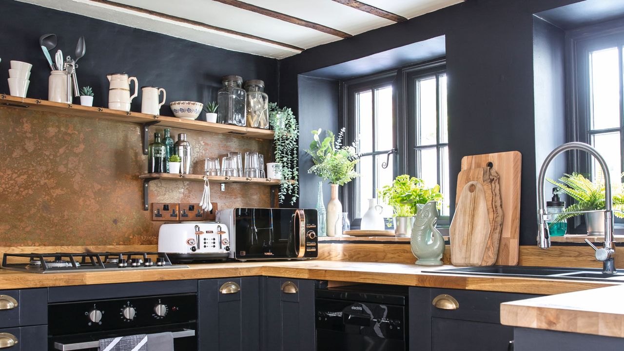 Dark kitchen colour scheme with wooden worktops and appliances on display