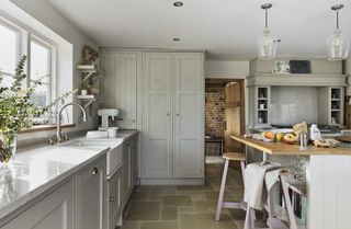 pale gray shaker kitchen with stone floor