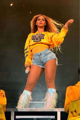 Beyonce Knowles wears a yellow cropped jumper and denim shorts as she performs onstage during 2018 Coachella Valley Music And Arts Festival Weekend 1 at the Empire Polo Field on April 14, 2018 in Indio, California.