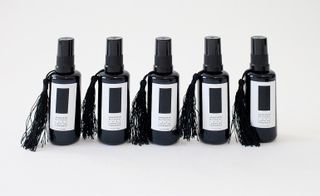 There are five perfume bottles are black in color