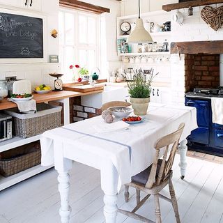 Kitchen with white walls microwave and table with chair
