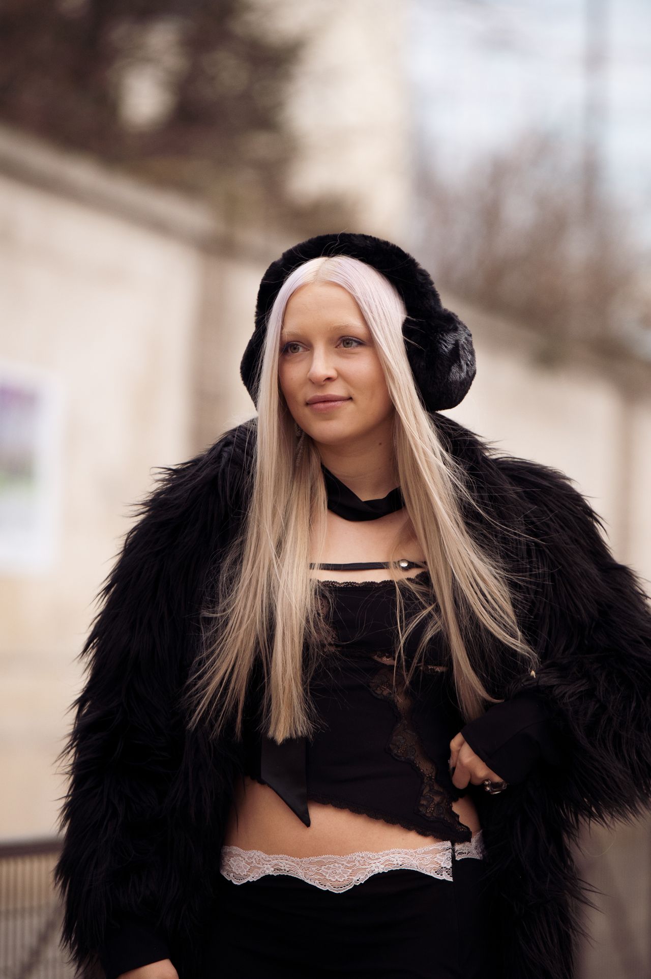 PARIS, FRANCE - FEBRUARY 28: A guest is seen wearing black boots, black silk skirt and matching top, fur coat and black ear covers outside Vaillant, during Paris Fashion Week - Womenswear Fall Winter 2023 2024, on February 28, 2023 in Paris, France. (Photo by Raimonda Kulikauskiene/Getty Images)