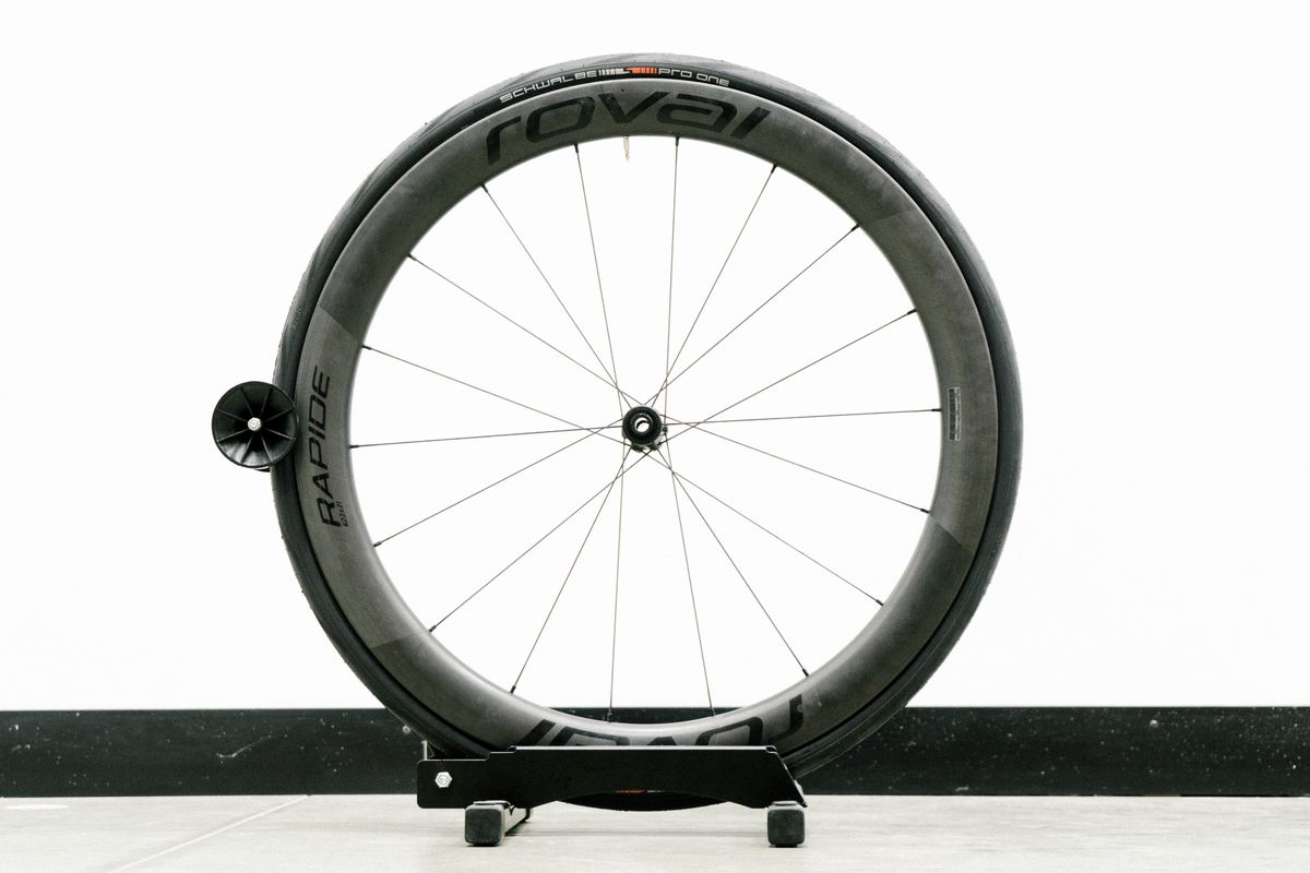 An aero road wheel stands against a white wall