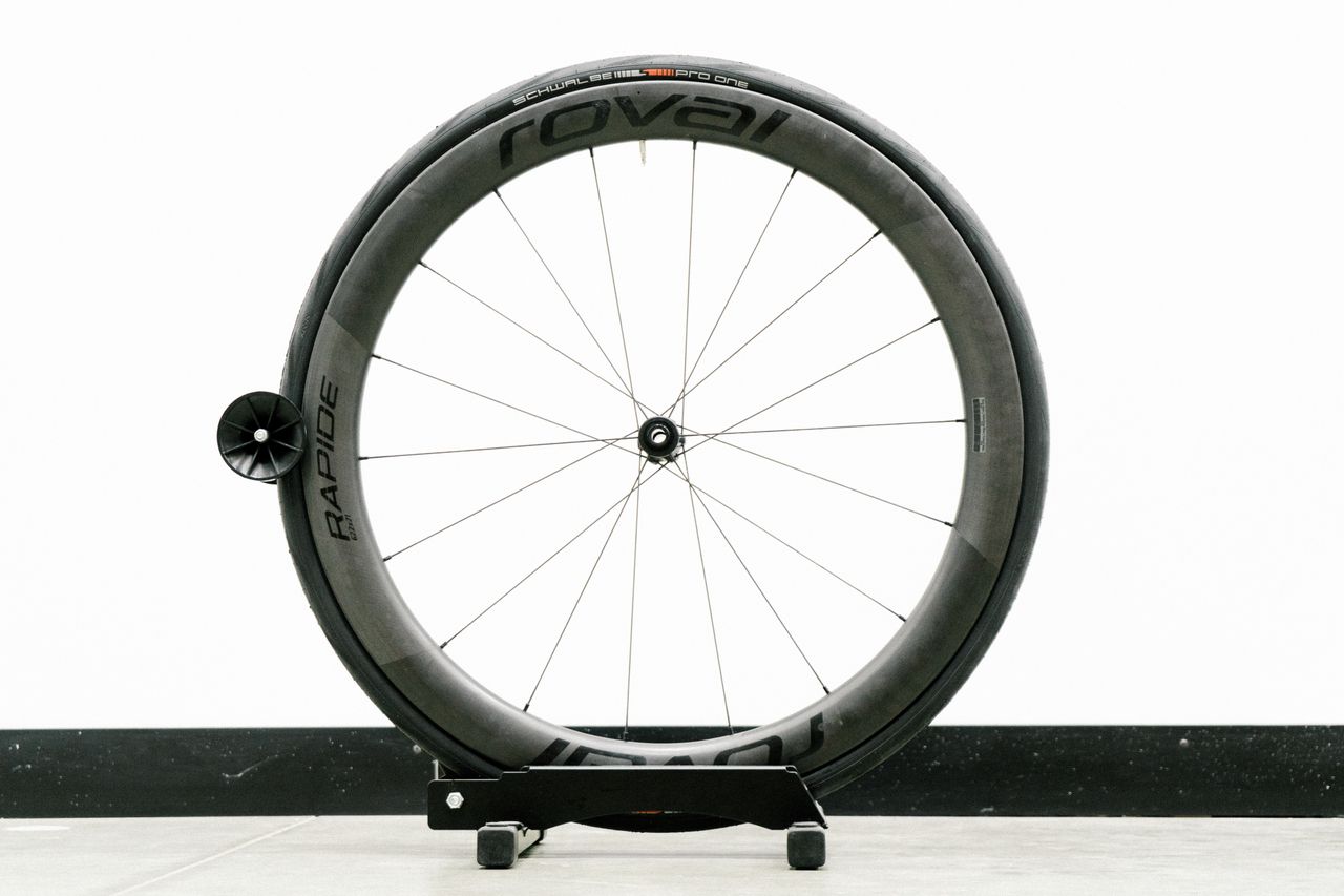 An aero road wheel stands against a white wall