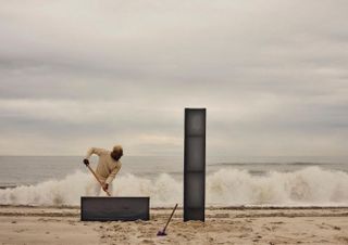 James Perkins on beach creating land art