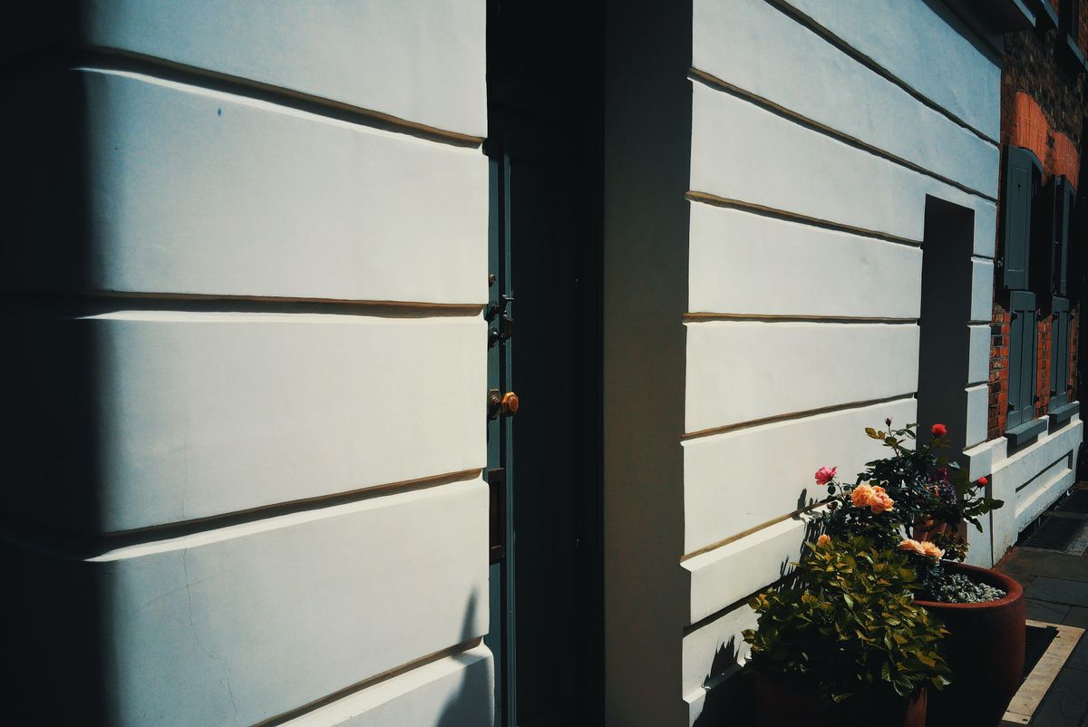 Photograph taken with the RewindPix digital compact showing a doorway in a white house with flowers outside, Cyberwarm film look