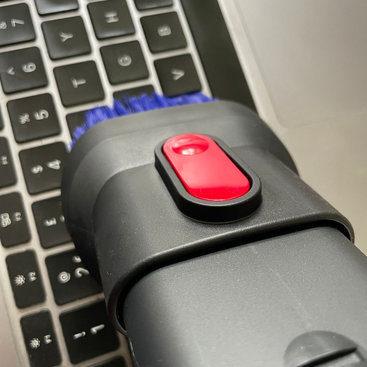 Using a vacuum upholstery tool to vacuum a keyboard