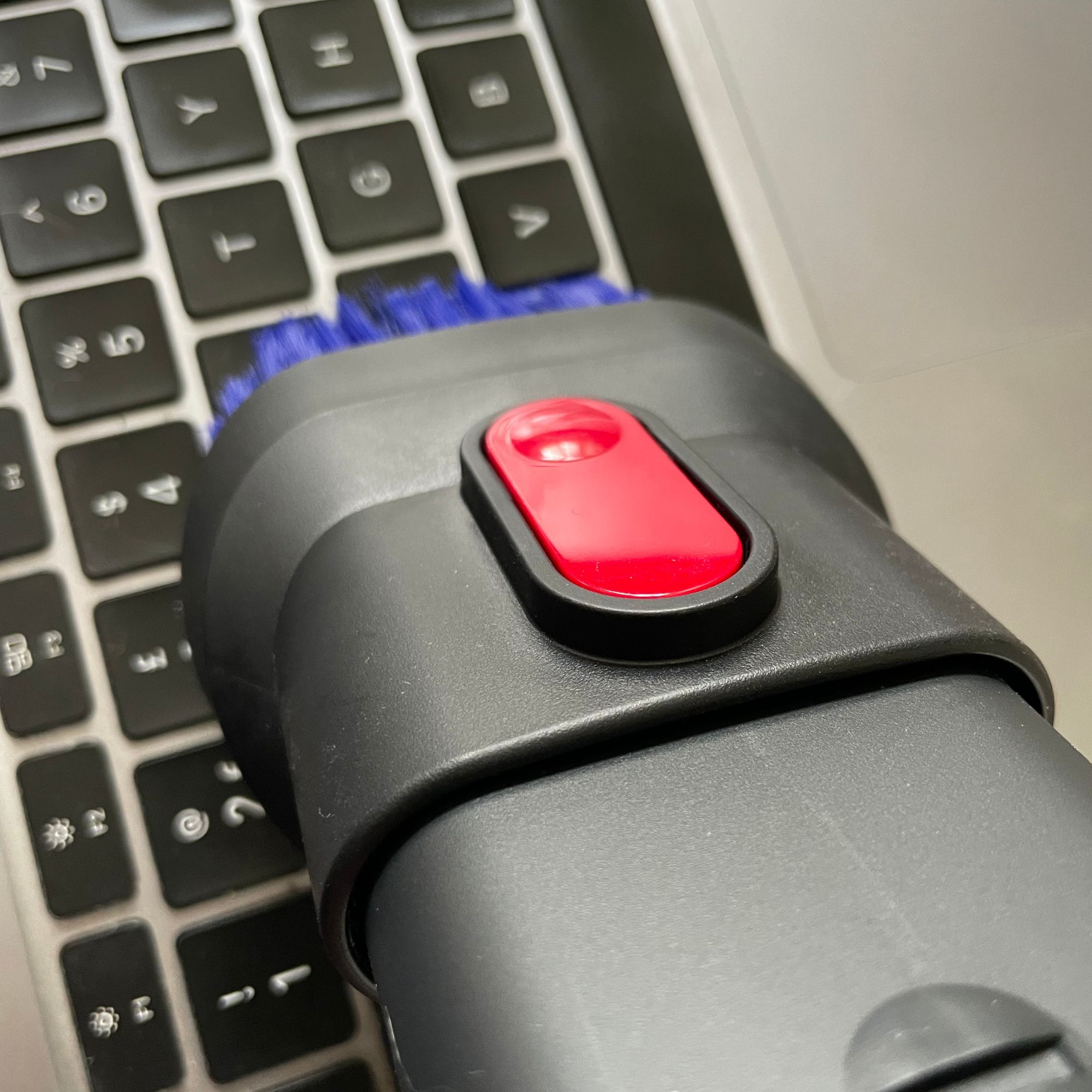 Using a vacuum upholstery tool to vacuum a keyboard