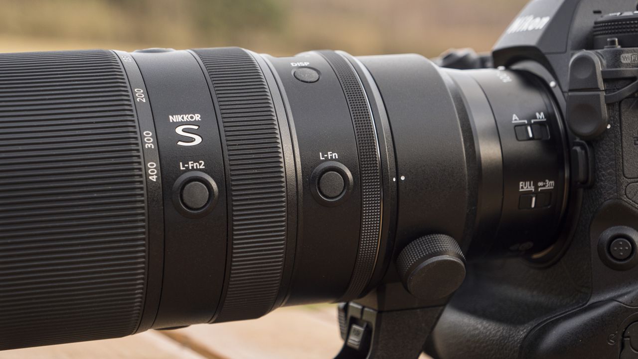 A Nikon Z telephoto lens on a wooden table