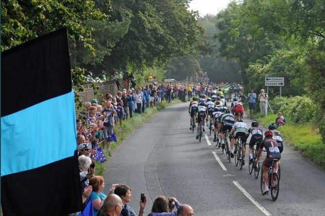The bunch is cheered along by numerous fans