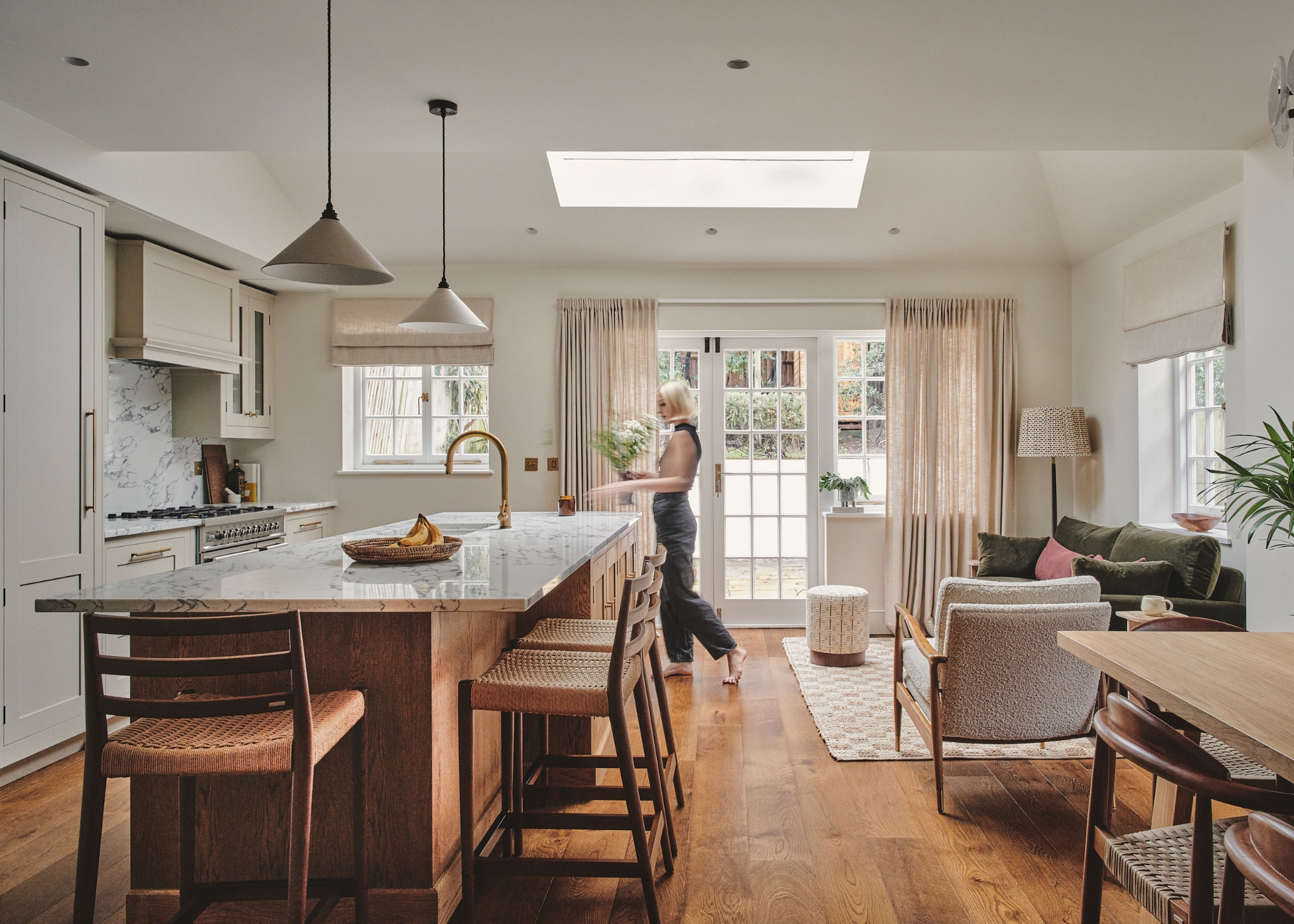 A neutral and dark wood open plan kitchen and living space with lots of natural light