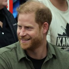 Prince Harry wears a khaki green shirt and smiles at the Invictus Games 2025 in Canada