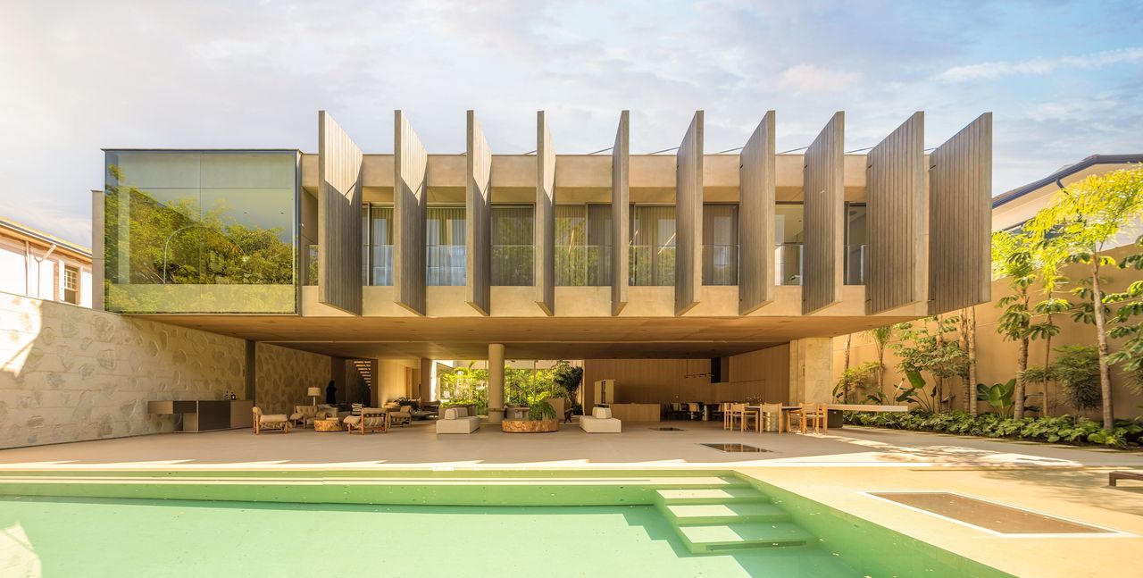 Pacaembu House garden facade with swimming pool and blue skies