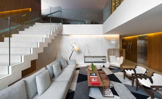 Living room view with long sofa and glass stair railings