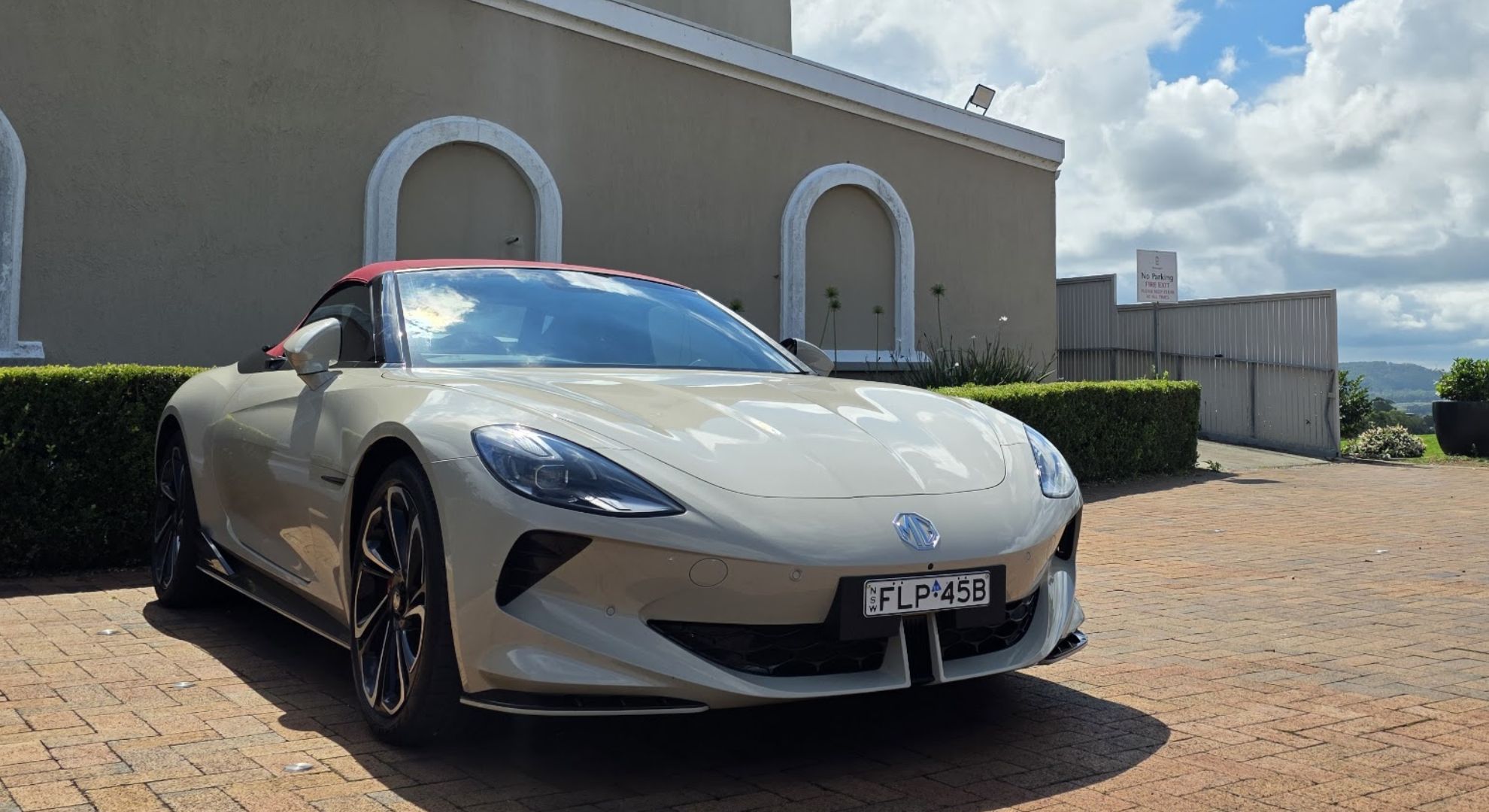 The MG Cyberster parked in front of a building