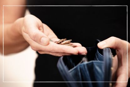 Close up of coins in woman&#039;s hand as she prepares to drop them into her purse