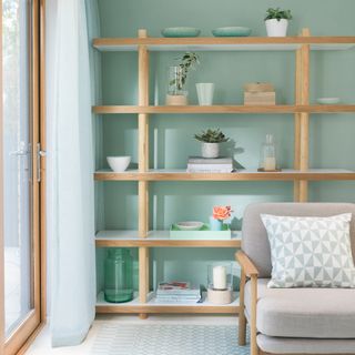 Mint green living room with contemporary open shelving with a curated display