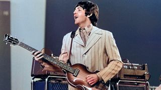 1966, British rock musician Paul McCartney playing on stage during The Beatles', last tour. Drummer Ringo Starr is visible in the background., 1966