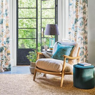 Mid-century wooden armchair in front of glass floor to ceiling doors