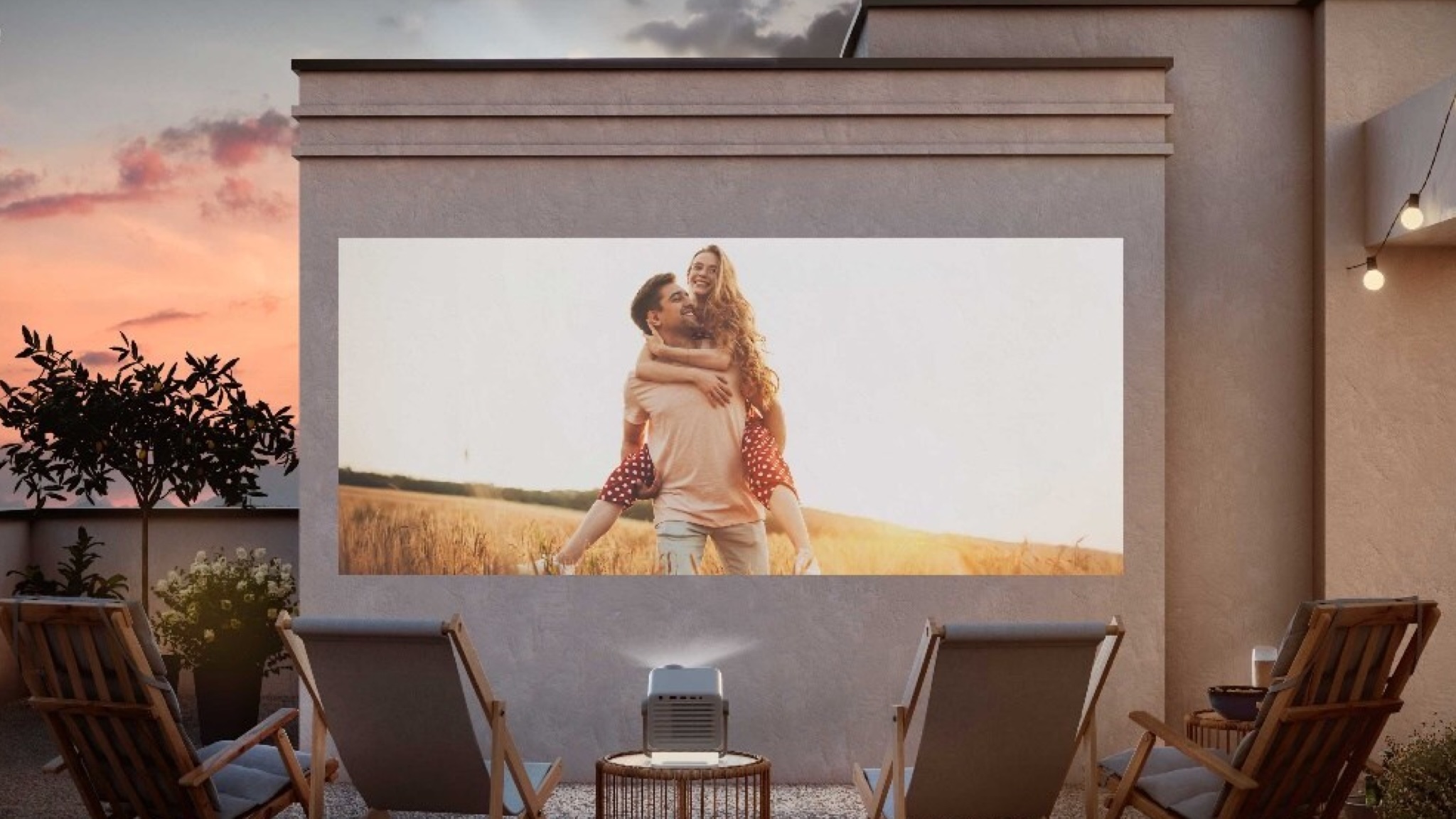 Lifestyle image showing the Hisense M2 Pro projecting on an exterior wall around sunset