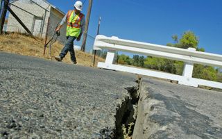 Ramon Martinez, of Monterey Co. Public Works, checks a crack in a bridge from an earthquake in Parkfield, California.