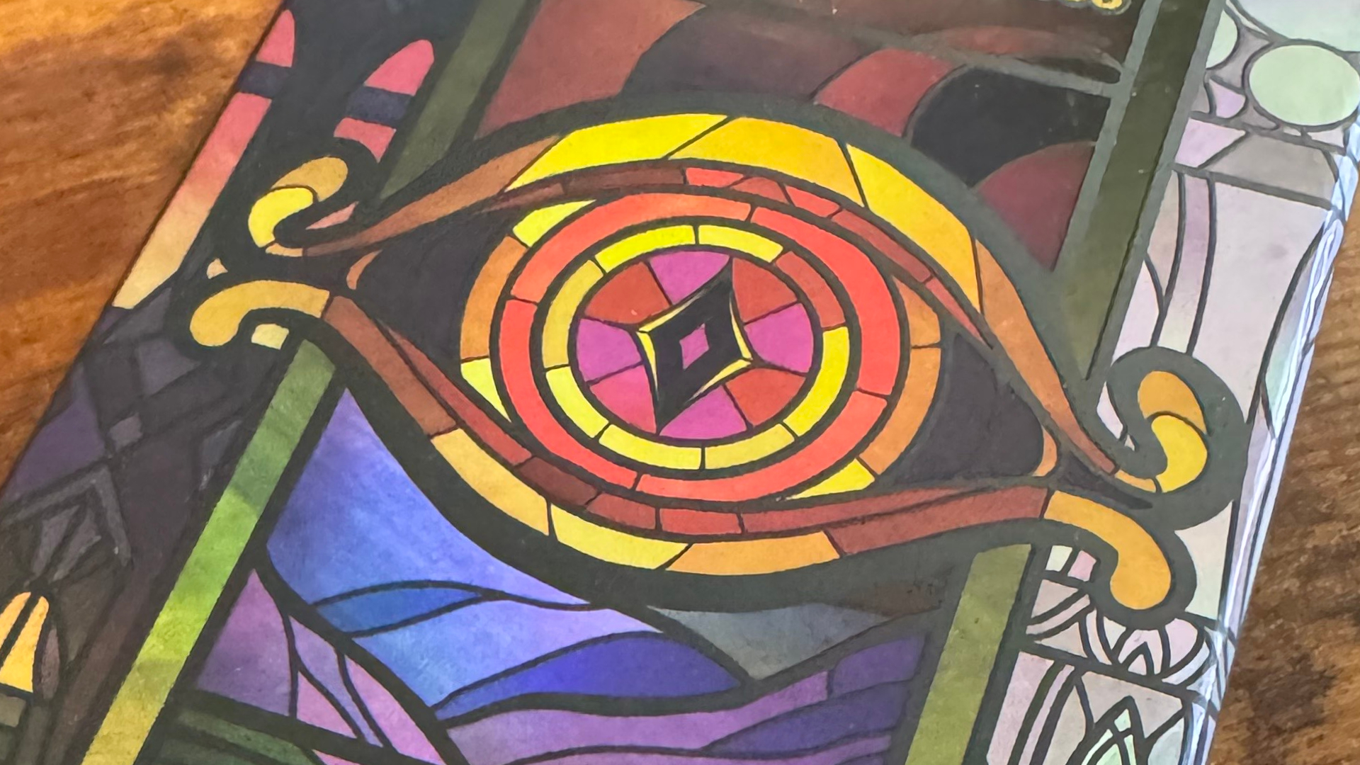 Sauron's eye depicted on the Two Towers Trick-Taking Game box, lying on a wooden table