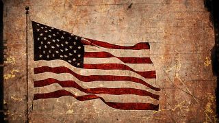 American flag flies against a sepia toned background