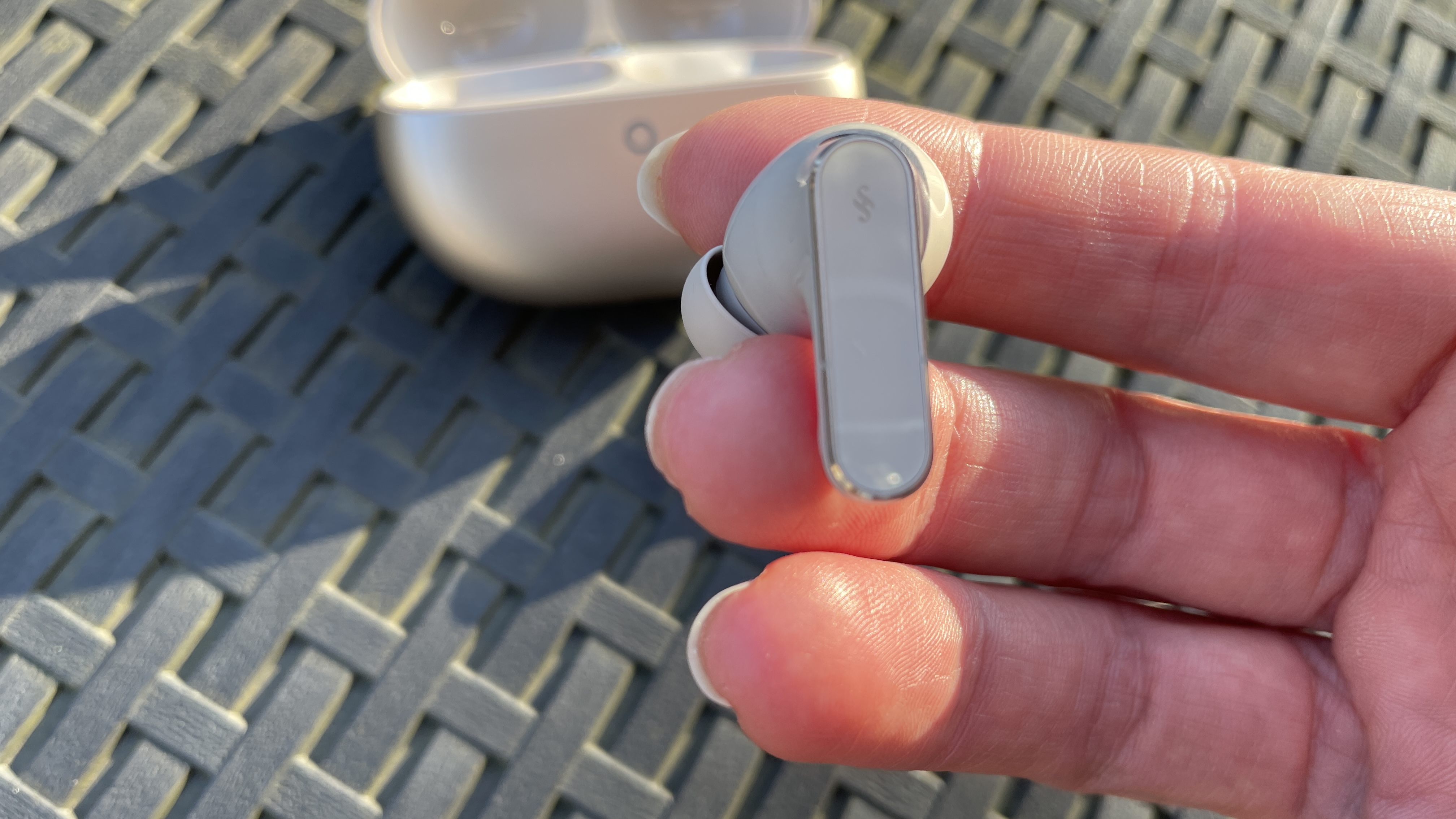 سماعات Huawei FreeBuds Pro 5 في الخارج، بالقرب من بعض أزهار النرجس البري، في شمس الظهيرة