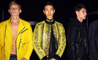 3 male models stood in a studio wearing black & yellow clothing