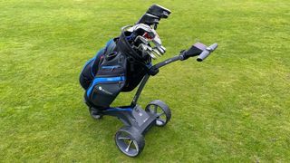 Motocaddy S5 GPS Electric Trolley stacked with a golf bag resting on the golf course