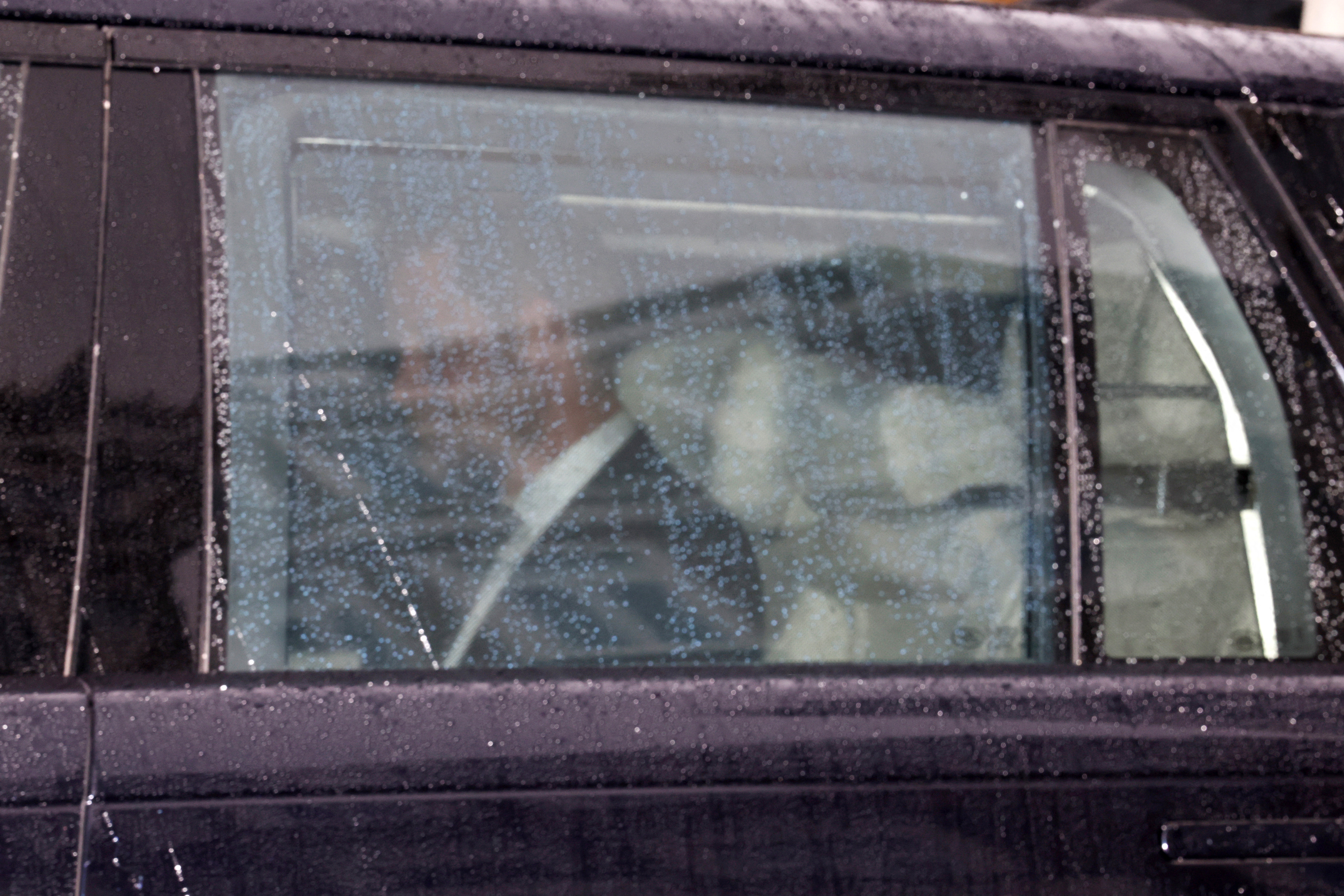 Prince Harry riding in a car in the rain