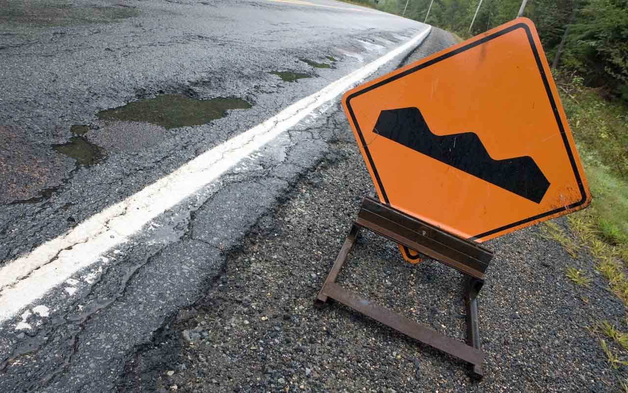 A &amp;quot;bump&amp;quot; sign sits beside a poor quality road.