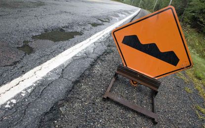 A "bump" sign sits beside a poor quality road.