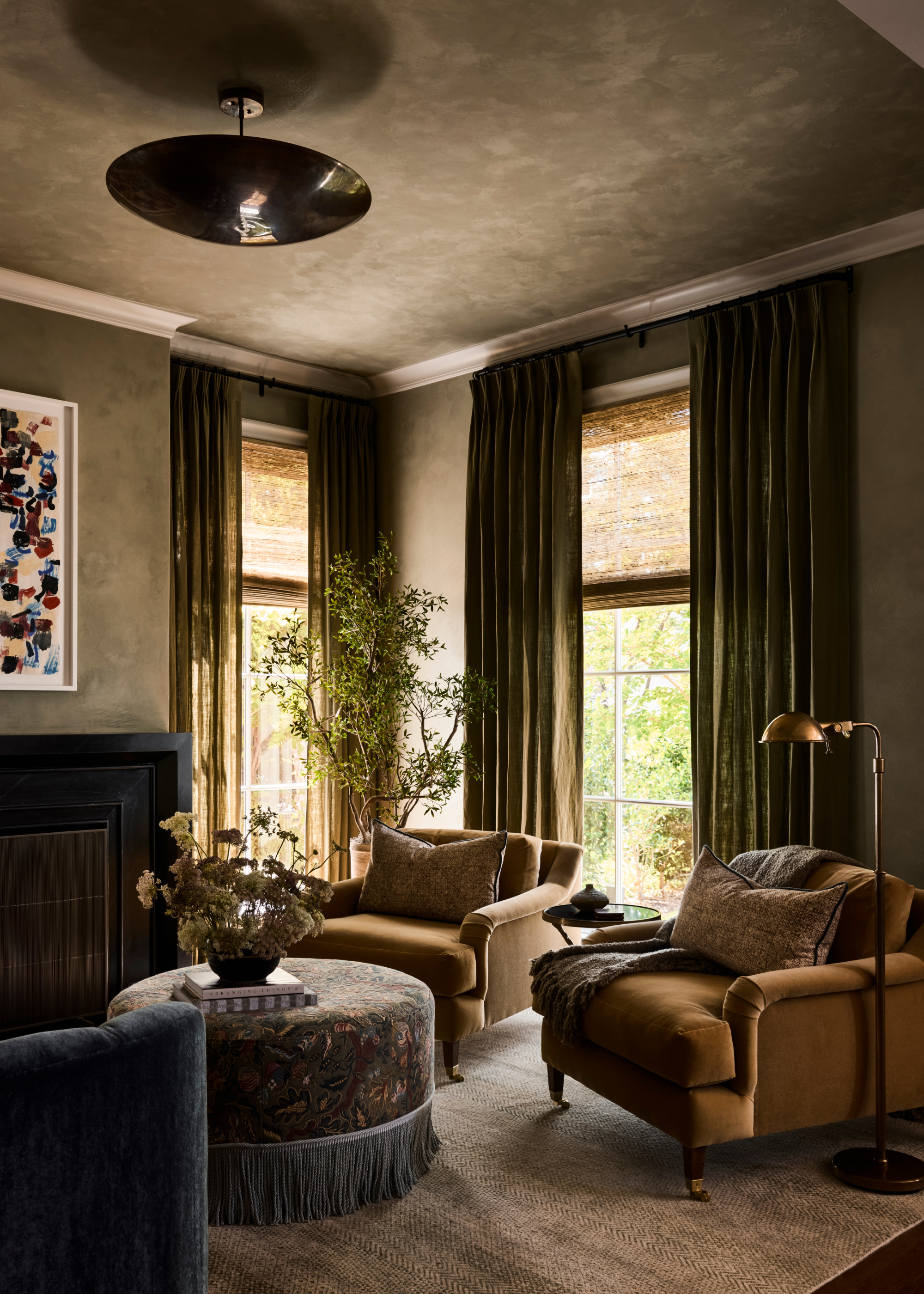 moody living room with green plastered color drenched walls and velvet furniture
