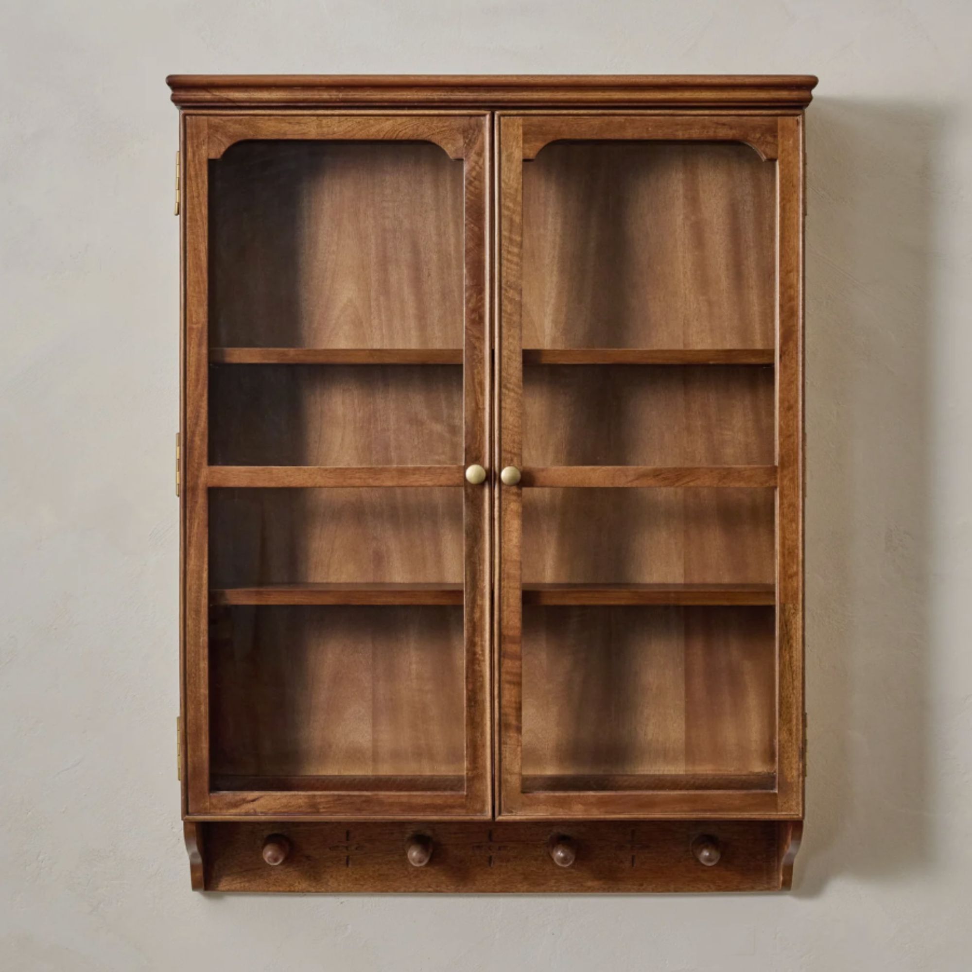 Warm wood kitchen cabinet with glass panels and pegs