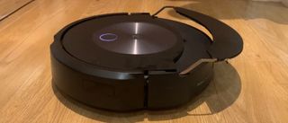 En robotstøvsuger av typen iRobot Roomba Combo j7+ i arbeid på et tregulv.