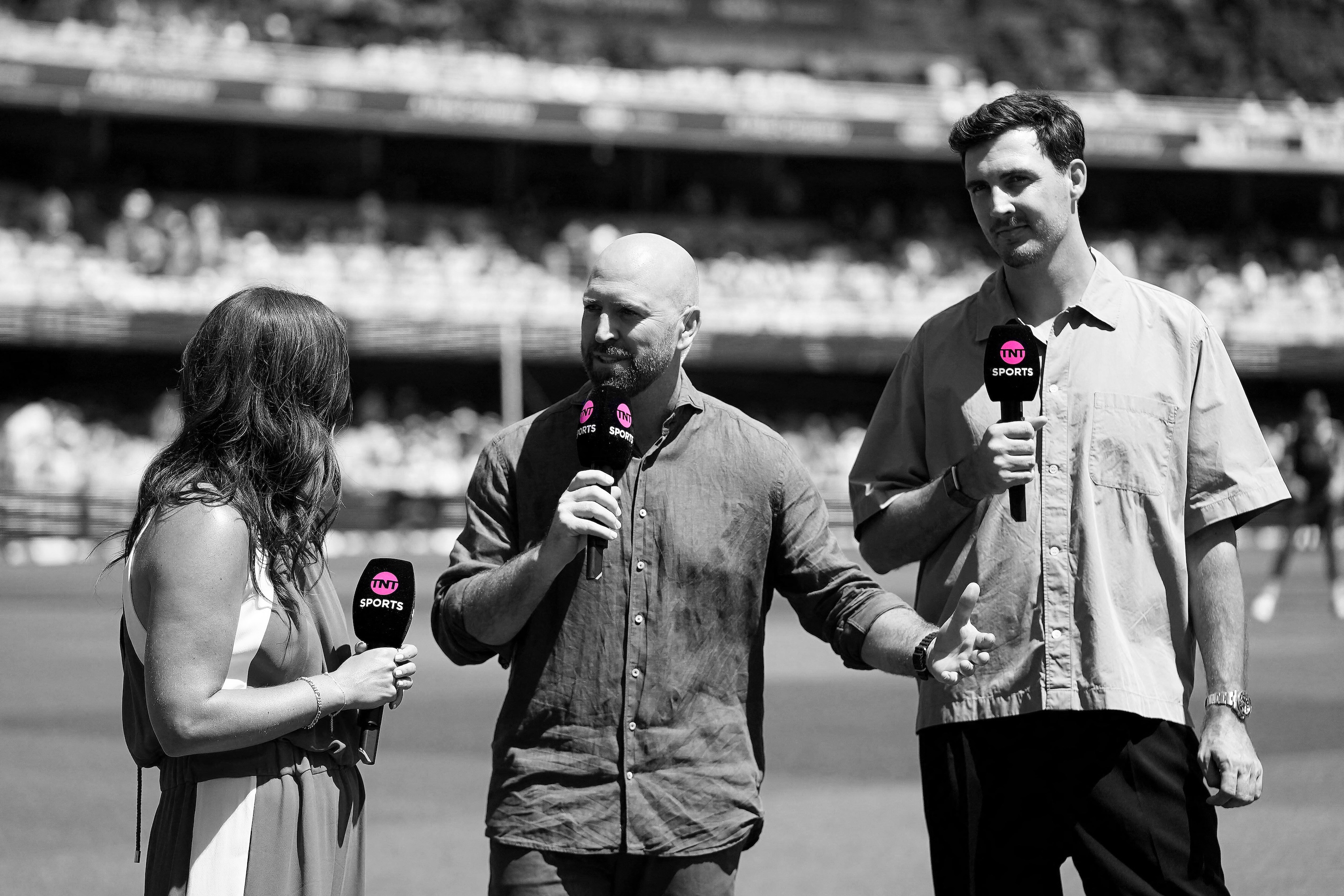 Three TV presenters at a cricket match