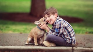 Sharing secrets - small boy and small dog