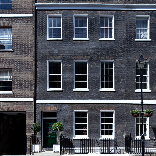 dark bricked building with white windows